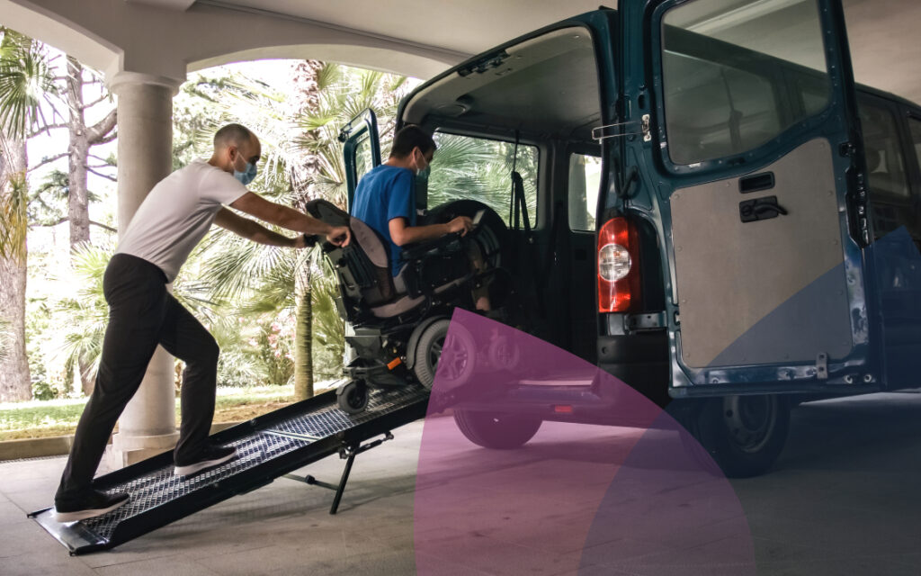 An NDIS Support Worker helps a Participant into the back of a wheelchair-accessible van