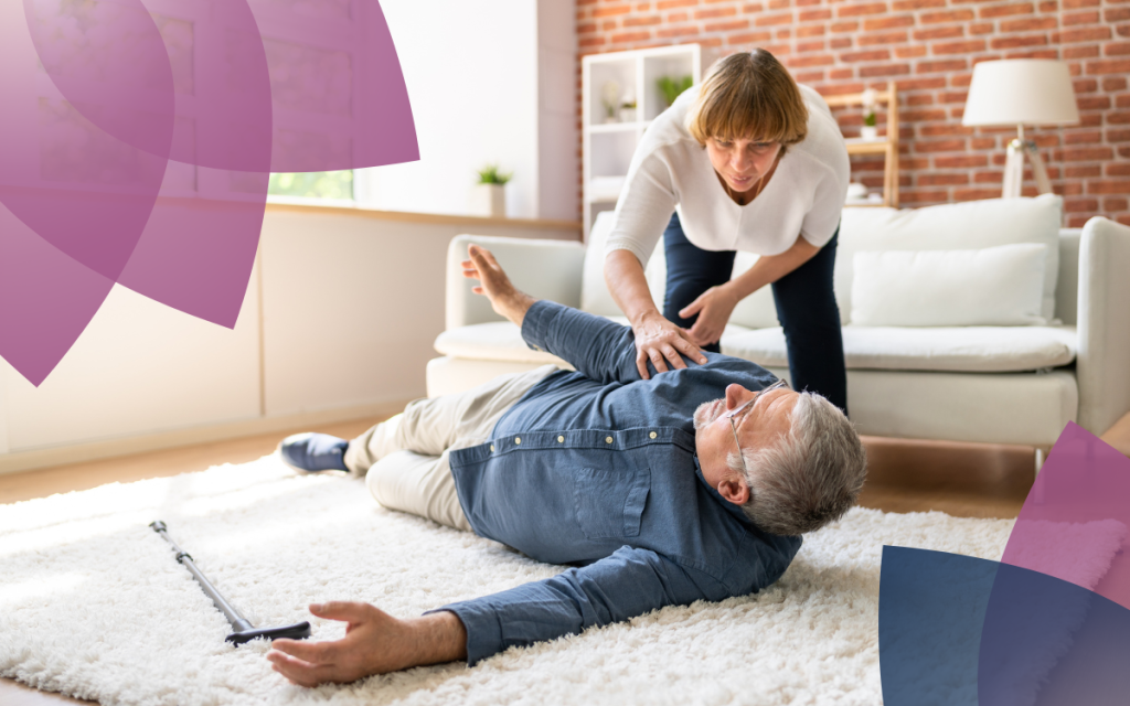 A woman helps a man with a cane who has fallen over on a white rug